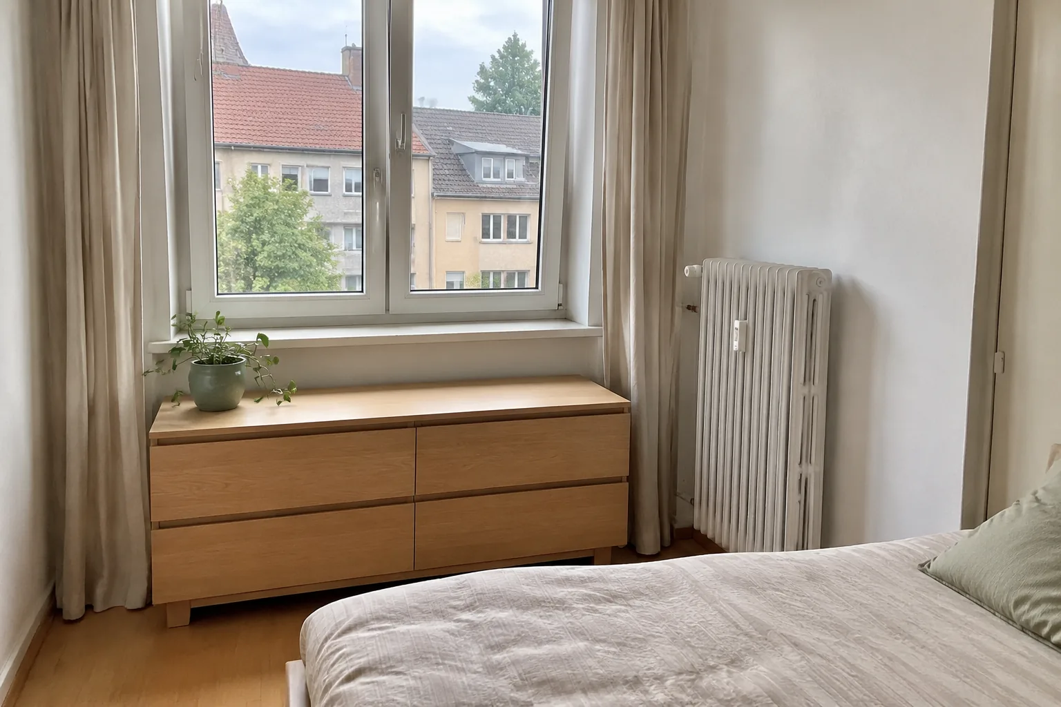 Niedrige Kommode als Stauraum unter einem freien Schlafzimmerfenster