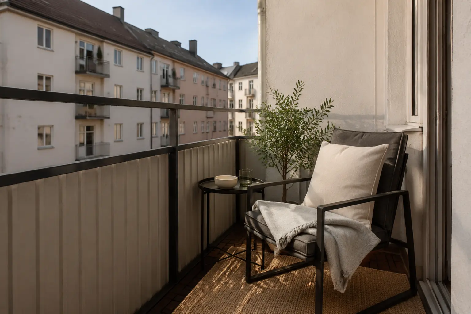 Gemütliche Ecklounge auf einem kleinen Balkon mit schmalem Outdoor-Sessel