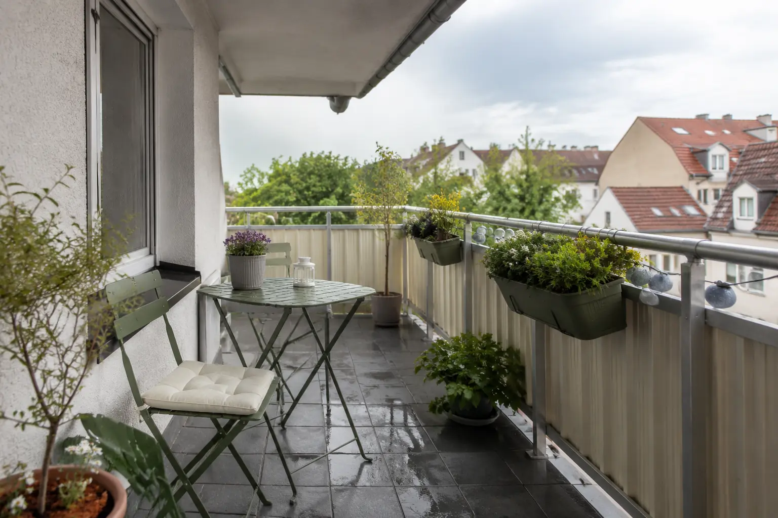 Wetterfeste kompakte Balkonmöbel mit gesicherten Töpfen an einem windigen Stadtbalkon